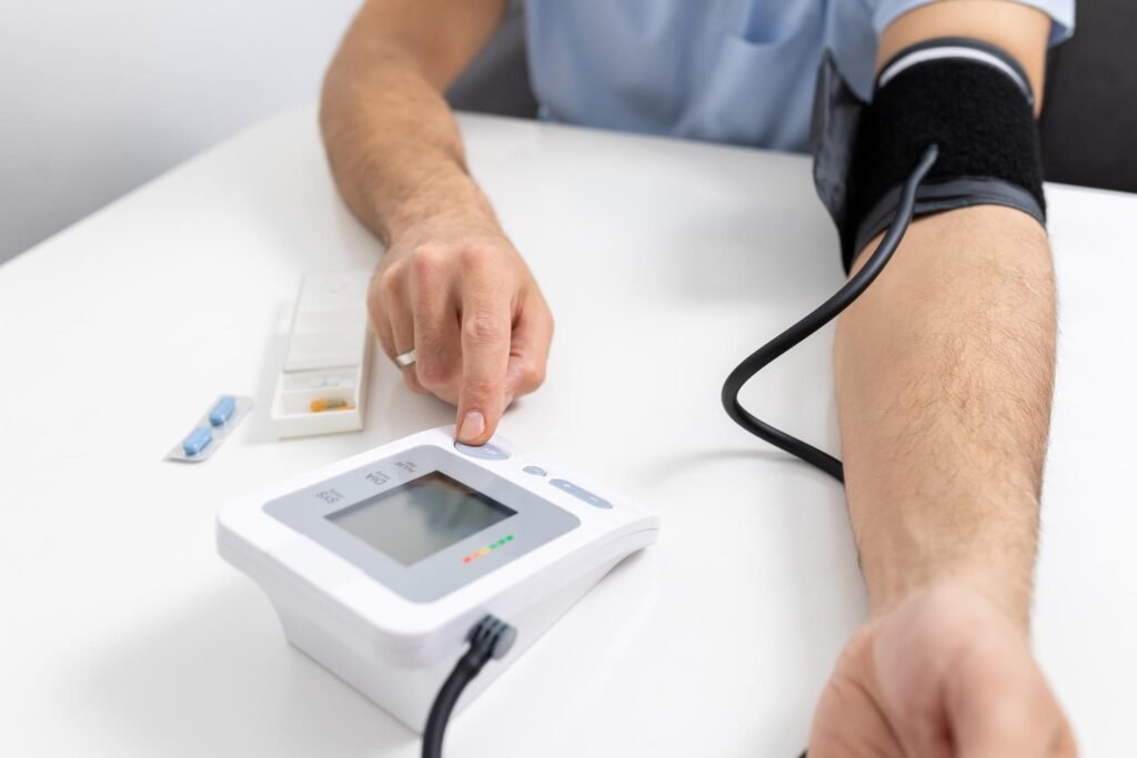 A person checking their systolic and diastolic readings using an automatic upper arm blood pressure monitor on a white table.